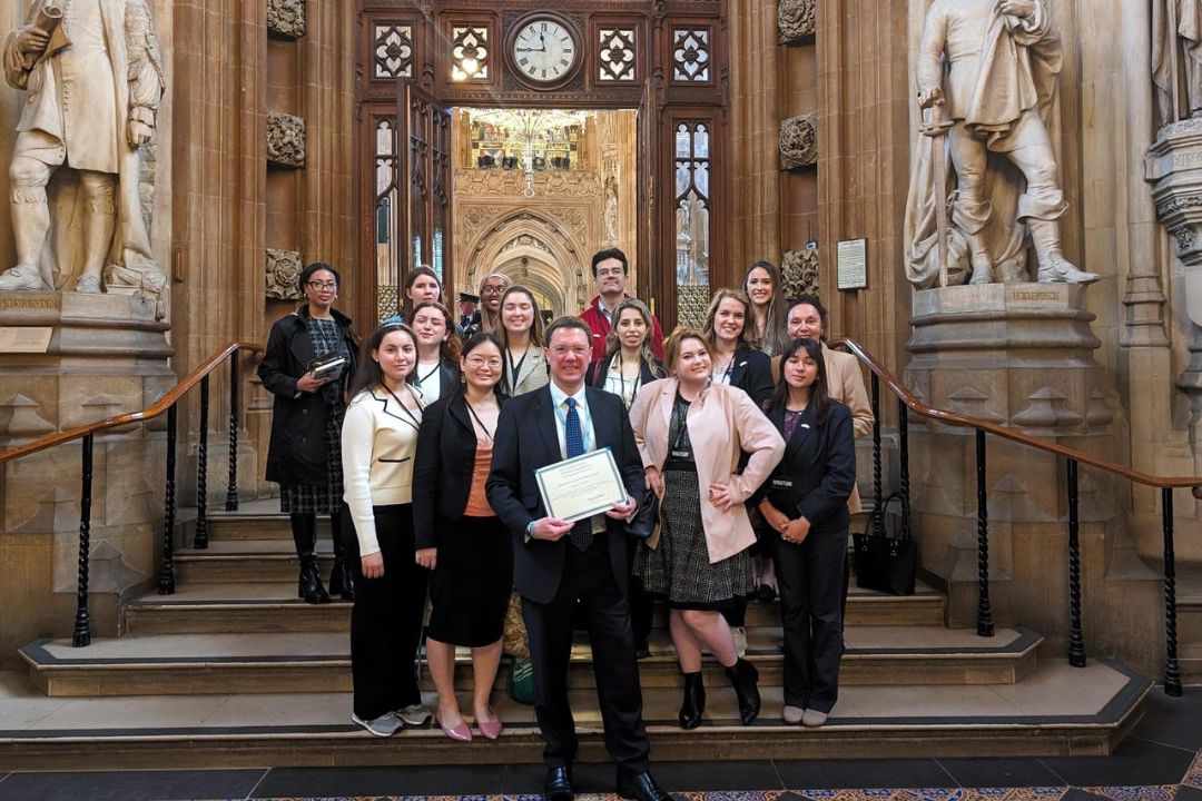 GSPM student group with politician UK in front of gothic architectural style building