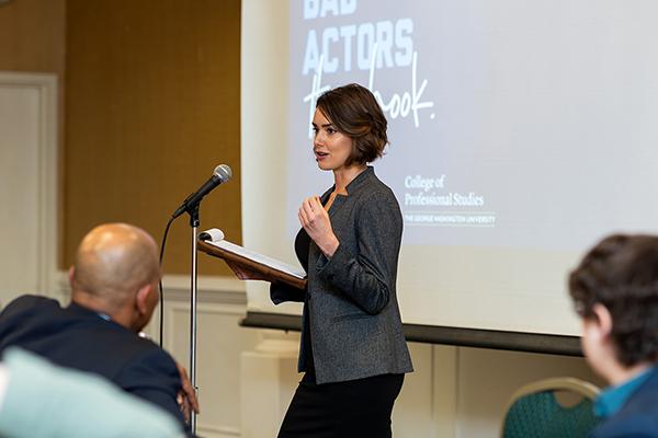 Woman presenting with a mic in front of a classroom screen