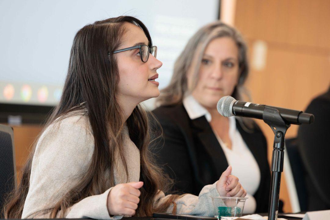 Two women at a panel with mic
